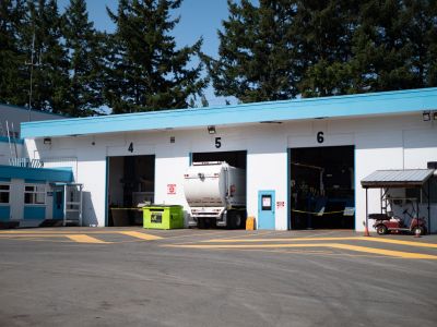 The Fleet building with a garbage truck not completely fitting in one of the bays.